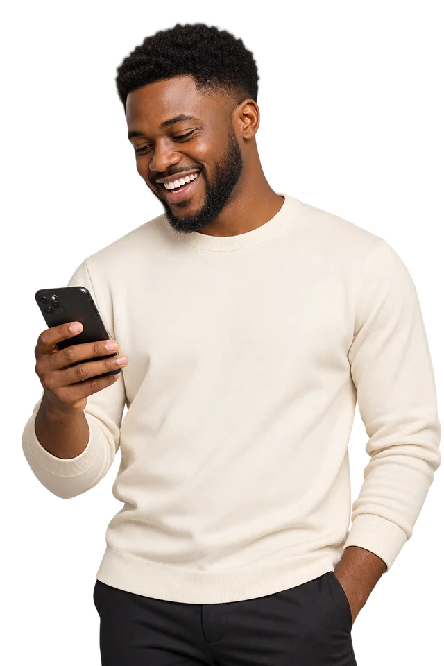 An African man smiling while looking at his phone